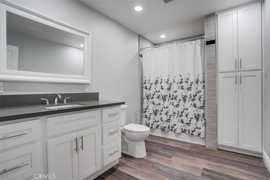 528 East 238th Place Carson, CA 90745 - Photo 45 of 75 a bathroom with a granite countertop sink a toilet a mirror and shower