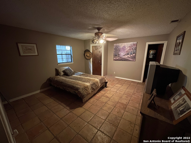 10671 Briggs Road Atascosa, TX 78002 - Photo 12 of 38 a bedroom with a bed and a flat screen tv
