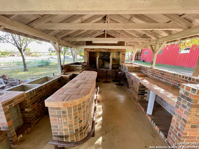 10671 Briggs Road Atascosa, TX 78002 - Photo 5 of 38 a view of a patio with table and chairs potted plants with wooden floor and seating space