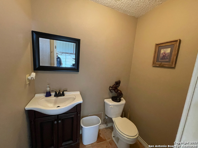 10671 Briggs Road Atascosa, TX 78002 - Photo 9 of 38 a bathroom with a toilet a sink and mirror