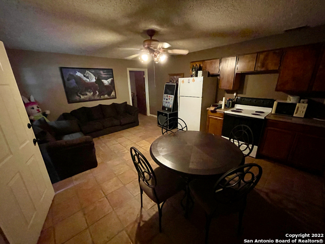 10671 Briggs Road Atascosa, TX 78002 - Photo 10 of 38 a living room with furniture a refrigerator and a flat screen tv