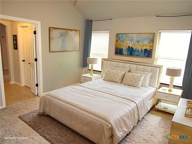 a bedroom with a bed and a painting on the wall