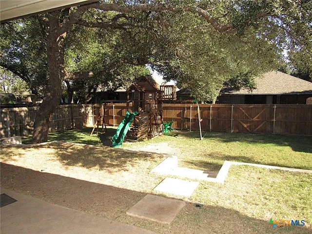 a view of a backyard with basketball court