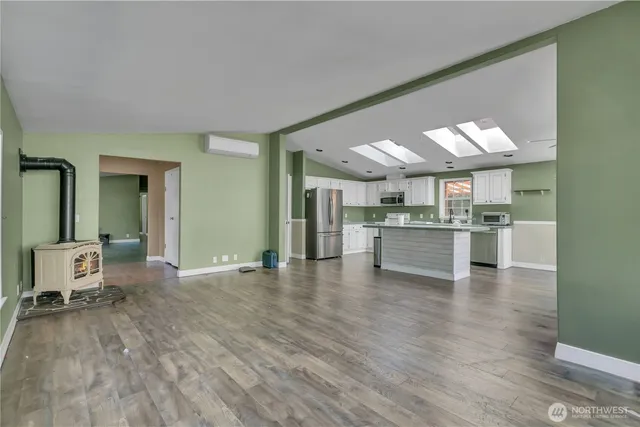 a view of a kitchen with kitchen island granite countertop a sink cabinets and wooden floor