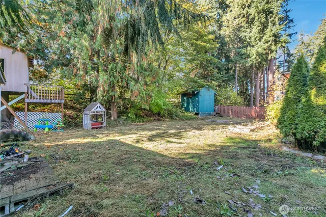 a view of a outdoor space with a house and trees in the background