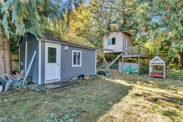 a view of a house with backyard and trees