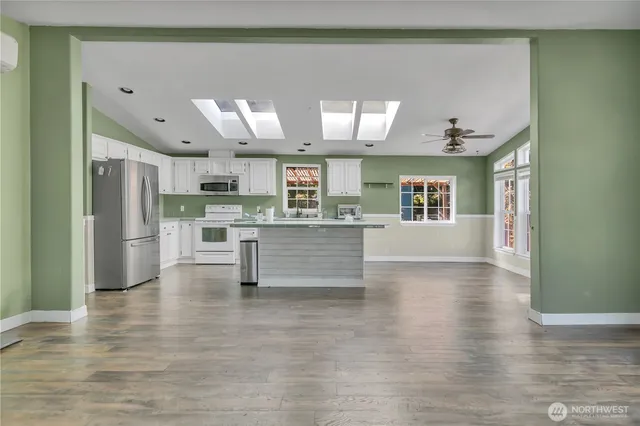 a view of kitchen with refrigerator stove and wooden floor