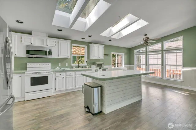 a kitchen with stainless steel appliances granite countertop a stove a sink dishwasher and a refrigerator