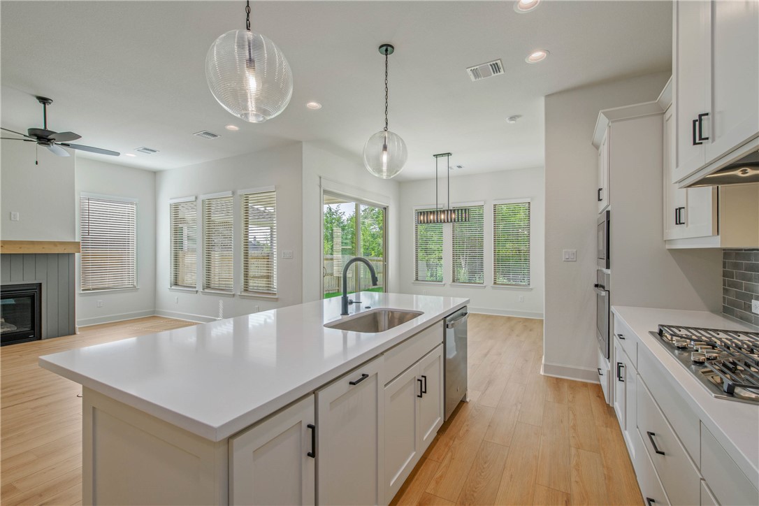 1652 Frontera Ranch Boulevard College Station, TX 77845 - Photo 27 of 29 a large kitchen with kitchen island a large counter space a sink appliances and cabinets