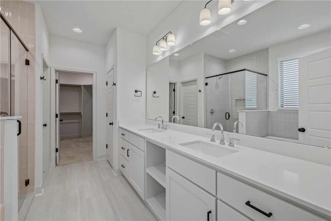1652 Frontera Ranch Boulevard College Station, TX 77845 - Photo 15 of 29 a spacious bathroom with a double vanity sink mirror double and shower