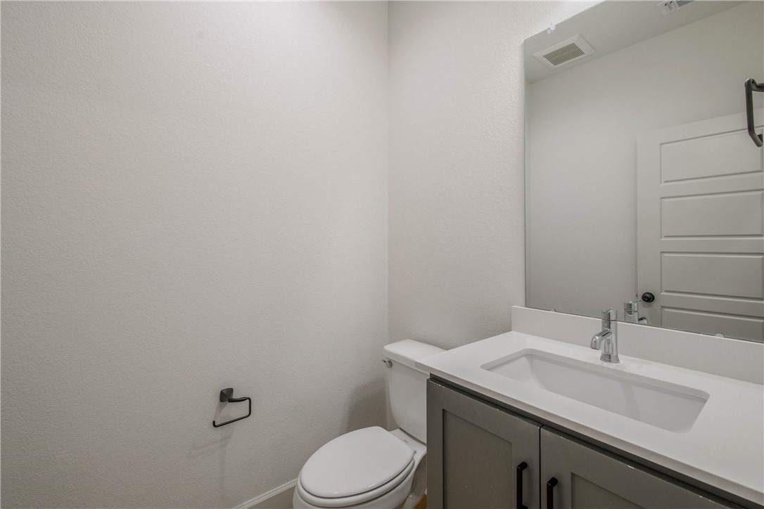 1652 Frontera Ranch Boulevard College Station, TX 77845 - Photo 18 of 29 a bathroom with a granite countertop toilet sink and mirror