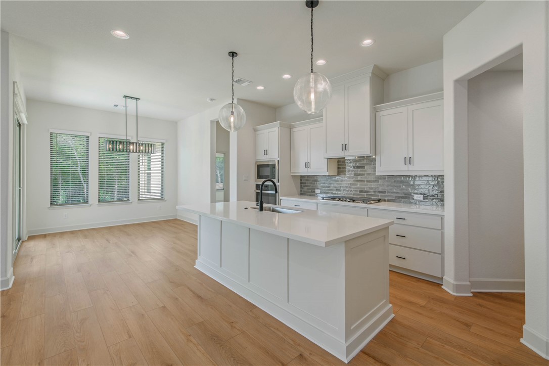 1652 Frontera Ranch Boulevard College Station, TX 77845 - Photo 9 of 29 a view of large kitchen with granite countertop stainless steel appliances sink stove and wooden floor