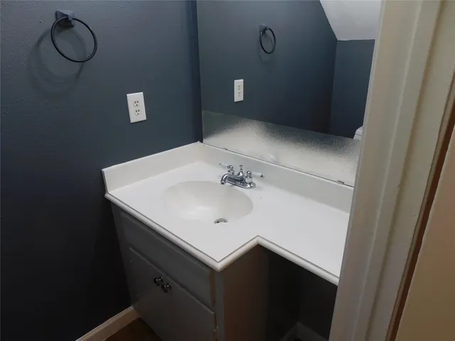 a bathroom with a sink vanity and a mirror