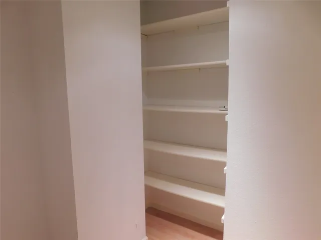a view of walk in closet with empty racks