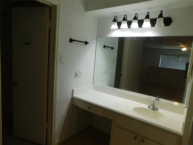a bathroom with a sink and two mirror