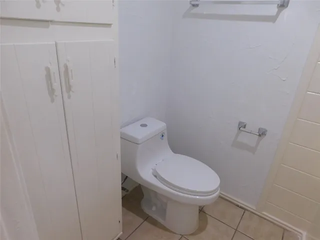 a white toilet sitting next to a shower