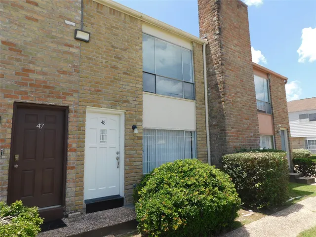 a brick house with a yard and plants