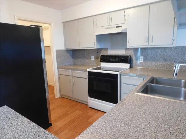 a kitchen with granite countertop a sink and a stove top oven