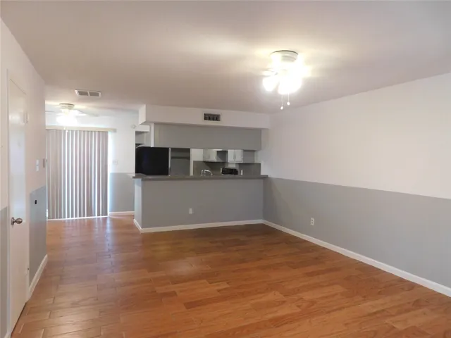 a view of a kitchen with a sink and an empty room