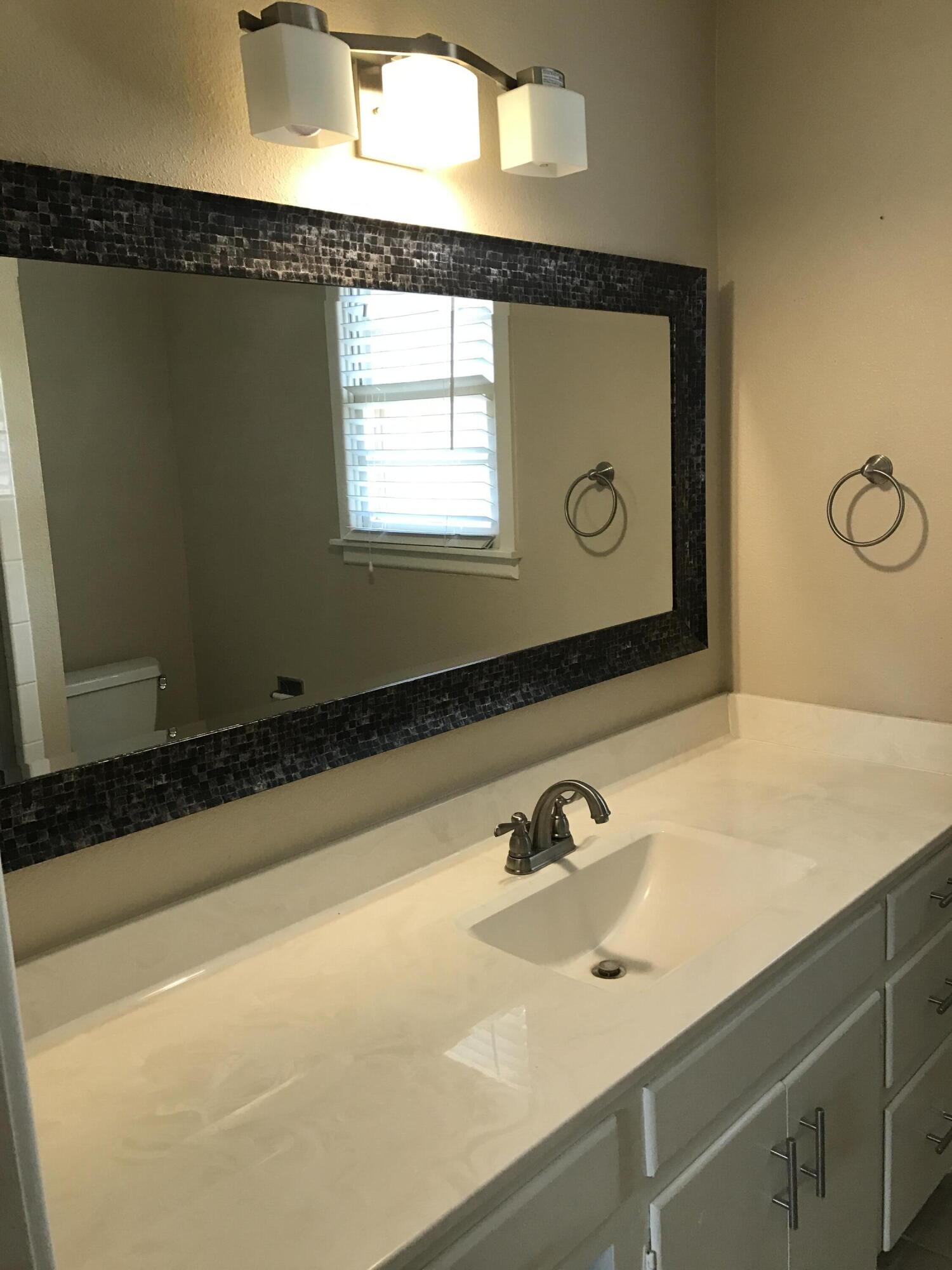 4409 27th Street Lubbock, TX 79410 - Photo 7 of 18 a bathroom with a sink and a mirror