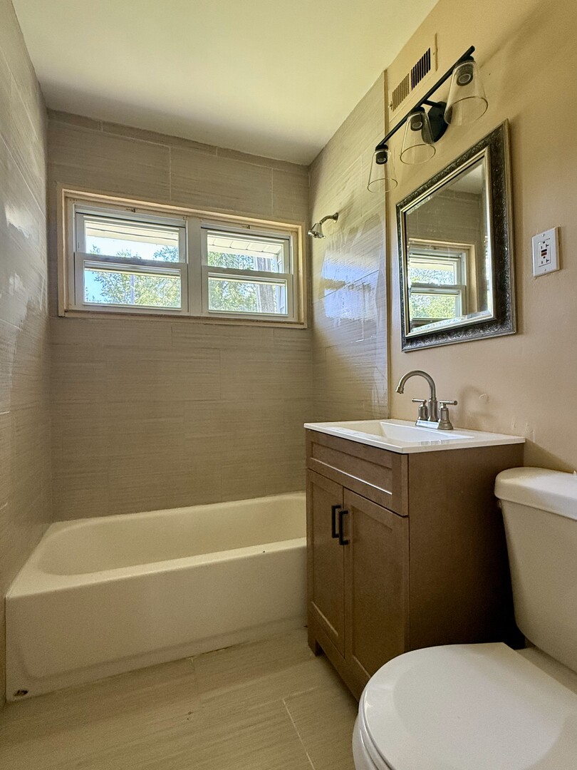 263 Allegheny Street Park Forest, IL 60466 - Photo 13 of 15 a bathroom with a sink a mirror a toilet and bathtub