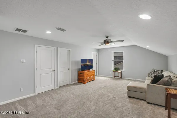 a living room with furniture and a ceiling fan