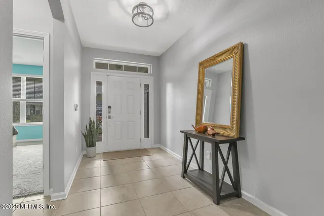 a view of an entryway with table and mirror