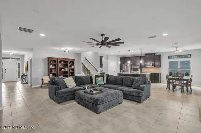 a living room with furniture and a ceiling fan