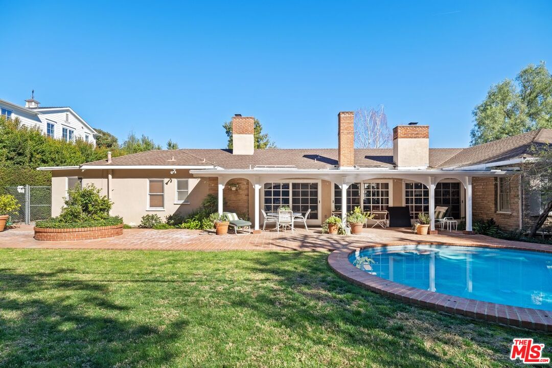 335 Homewood Road Los Angeles, CA 90049 - Photo 12 of 17 a front view of a house with swimming pool having outdoor seating