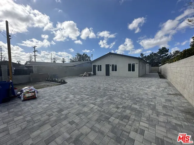 a view of a white house with a yard and sitting area