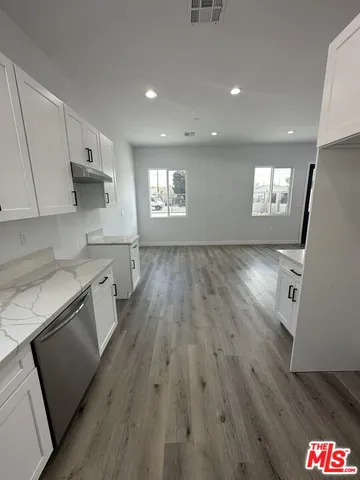 a kitchen with wooden floors and white appliances