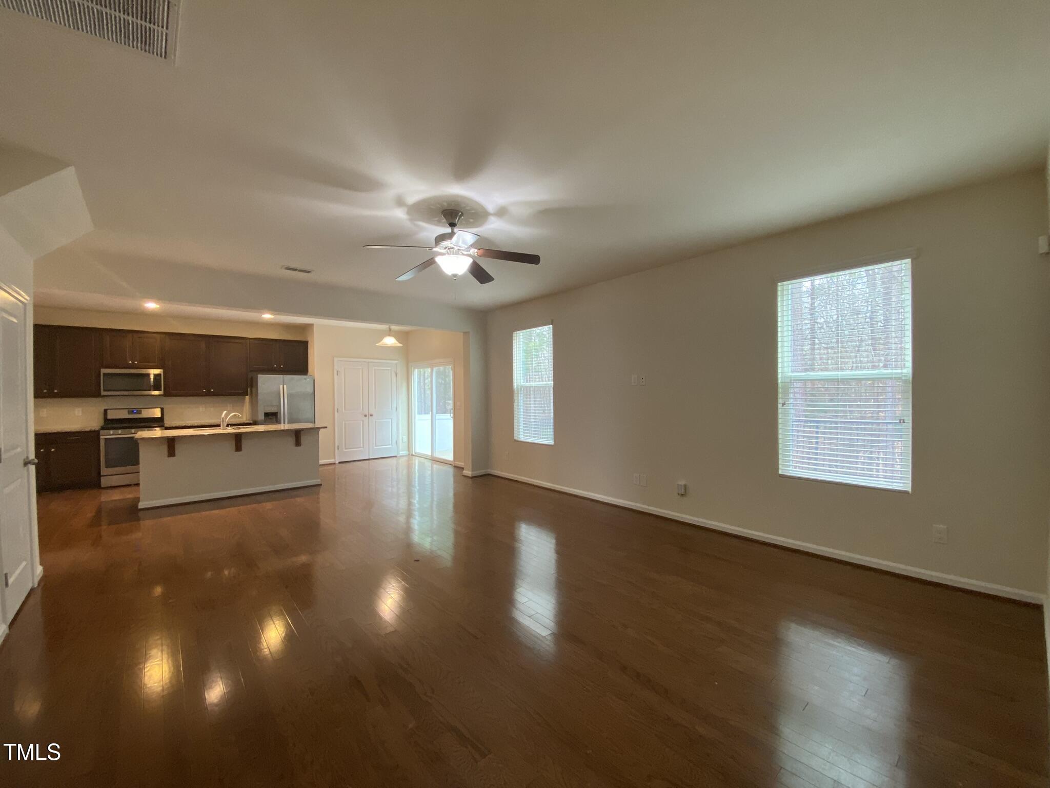 3545 Massey Ridge Court Raleigh, NC 27616 - Photo 14 of 38 a view of an empty room and kitchen with wooden floor