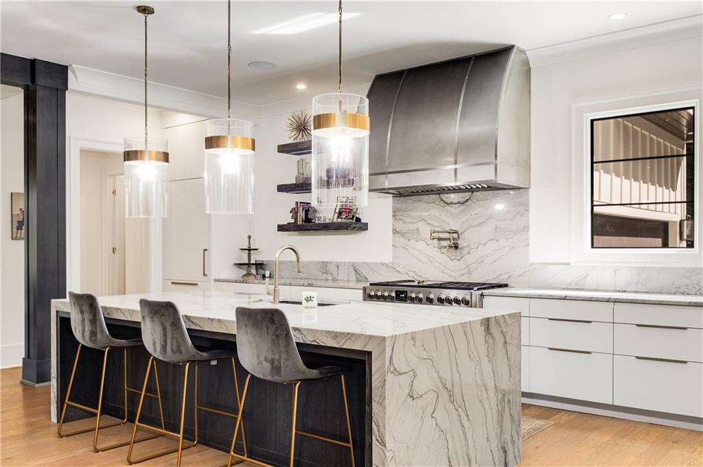 306 Pinecrest Road Northeast Atlanta, GA 30342 - Photo 12 of 67 a kitchen with stainless steel appliances kitchen island granite countertop a table chairs in it and wooden floors