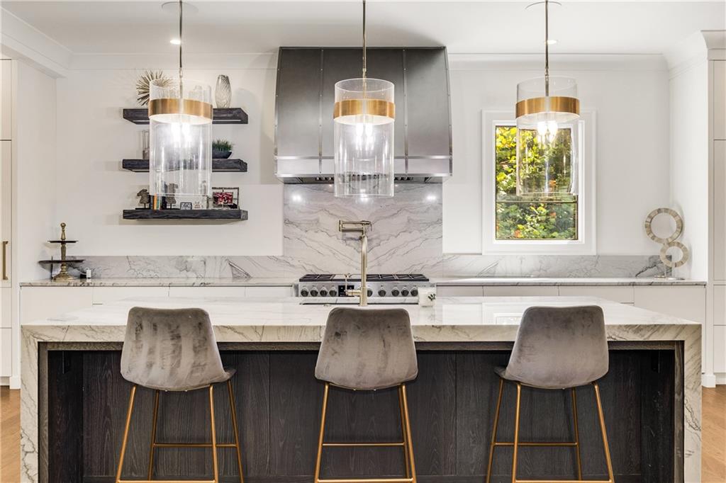 306 Pinecrest Road Northeast Atlanta, GA 30342 - Photo 13 of 67 a kitchen with stainless steel appliances granite countertop a stove a sink dishwasher a window cabinets and a dining table with chairs