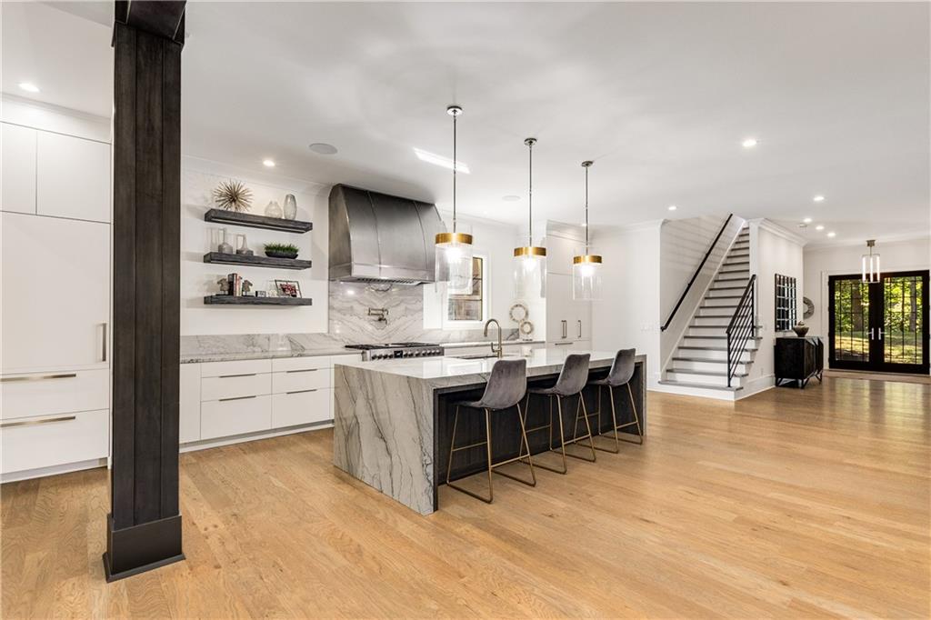 306 Pinecrest Road Northeast Atlanta, GA 30342 - Photo 17 of 67 a large kitchen with kitchen island a sink a stove a dining table and chairs