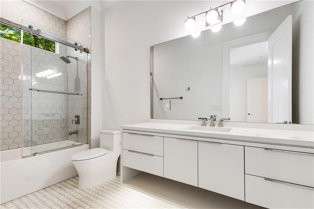 306 Pinecrest Road Northeast Atlanta, GA 30342 - Photo 43 of 67 a bathroom with a toilet a sink a tub and mirror