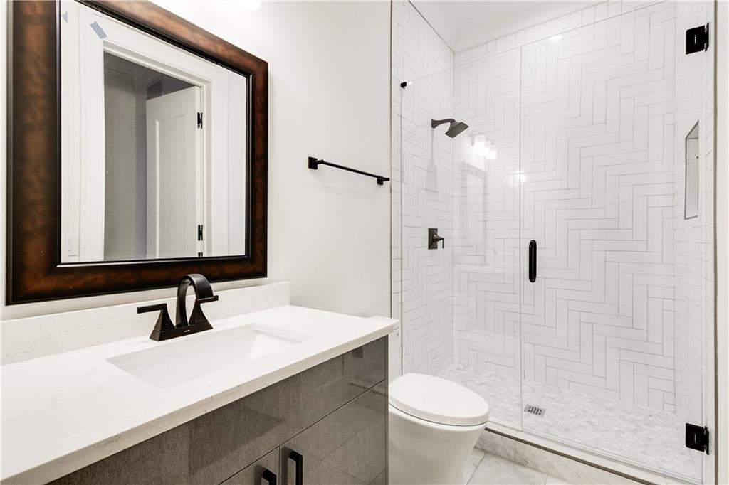 306 Pinecrest Road Northeast Atlanta, GA 30342 - Photo 52 of 67 a bathroom with a sink a toilet a mirror and shower