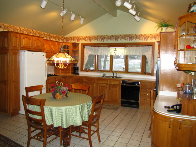 170 Montgomery Road Montgomery, IL 60538 - Photo 3 of 25 a kitchen with a sink a stove and chairs