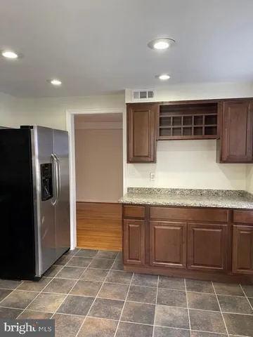 a kitchen with a sink a refrigerator and cabinets