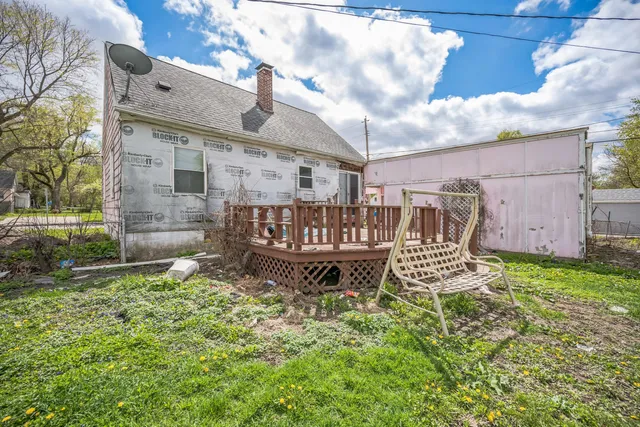 a view of a chair and table in backyard of the house