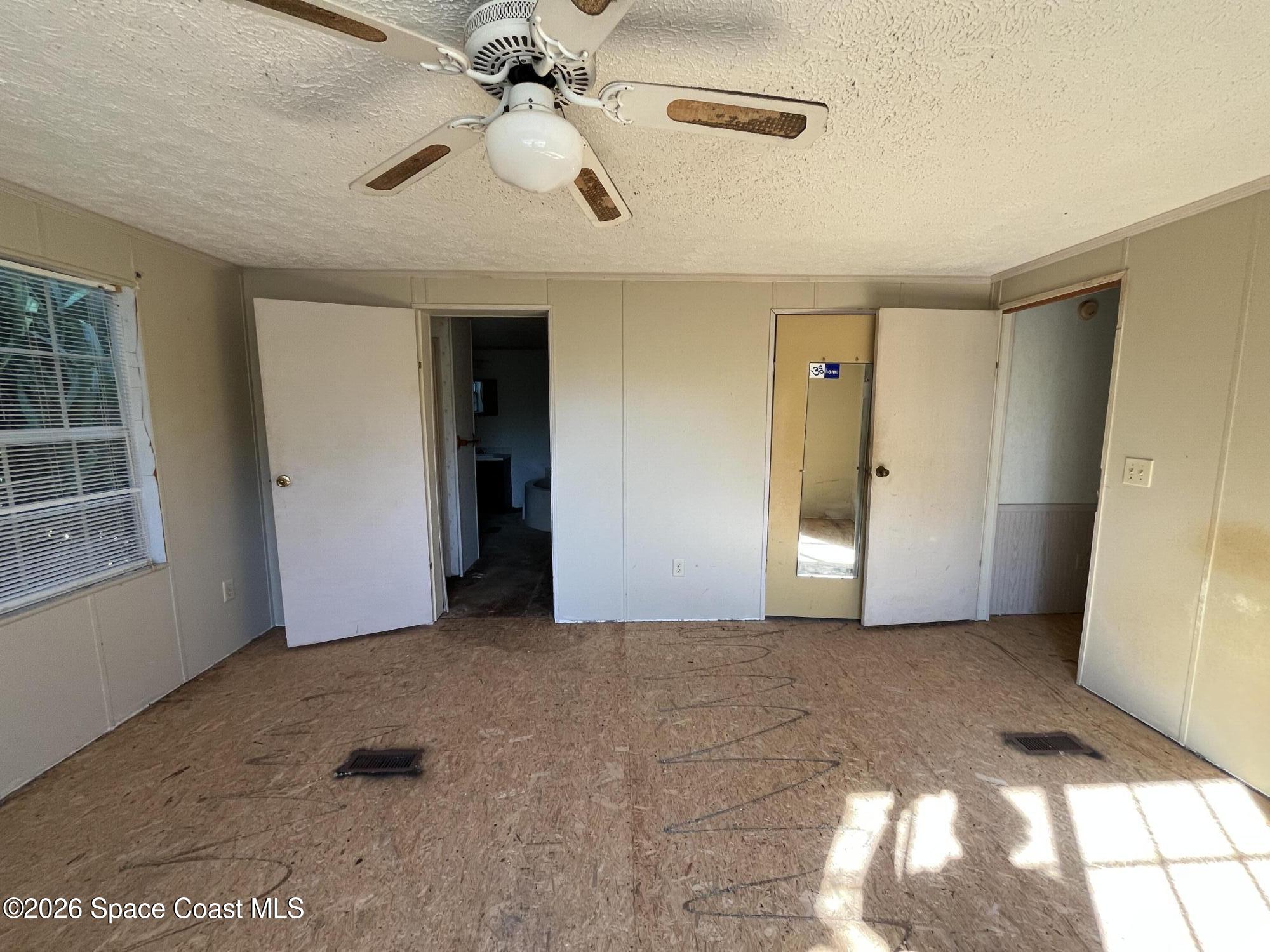 180 Rita Boulevard Melbourne Beach, FL 32951 - Photo 6 of 10 en empty room with windows and ceiling fan