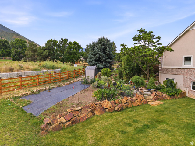 1317 South Pond Circle Mapleton, UT 84664 - Photo 47 of 63 Expansive backyard featuring a manicured lawn, established landscaping, and a tiered rock garden