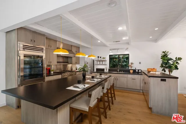 a kitchen with stainless steel appliances granite countertop a sink counter space and living room view
