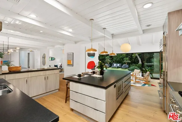 a kitchen that has a lot of cabinets and a wooden floor
