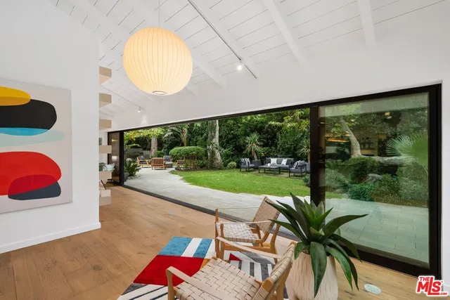 a living room with patio furniture and a floor to ceiling window