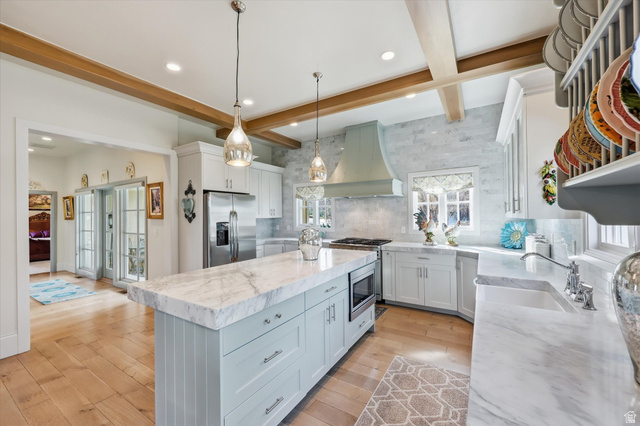 930 Price Farm Court Midway, UT 84049 - Photo 17 of 42 Dual tone kitchen with backsplash, marble counters, a kitchen island, beamed ceiling, and stainless steel appliances