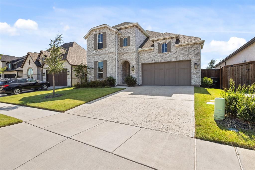 Two-story stone exterior featuring a covered entry, arched windows, and a double-wide driveway