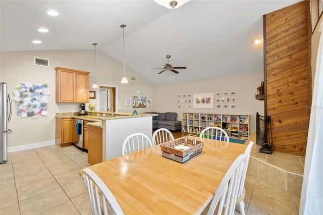 a kitchen with kitchen island a stove a sink a oven a dining table and chairs