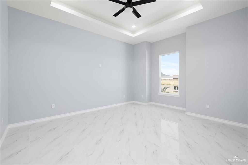3708 Canan Street Weslaco, TX 78596 - Photo 6 of 13 an empty room with a window and a ceiling fan