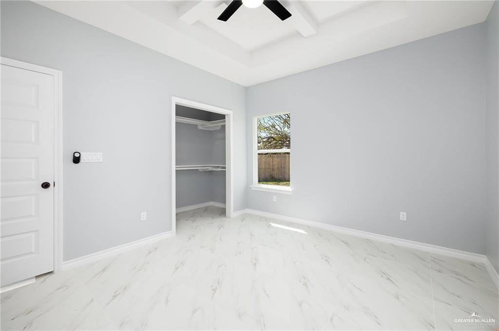 3708 Canan Street Weslaco, TX 78596 - Photo 10 of 13 an empty room with chandelier fan and windows